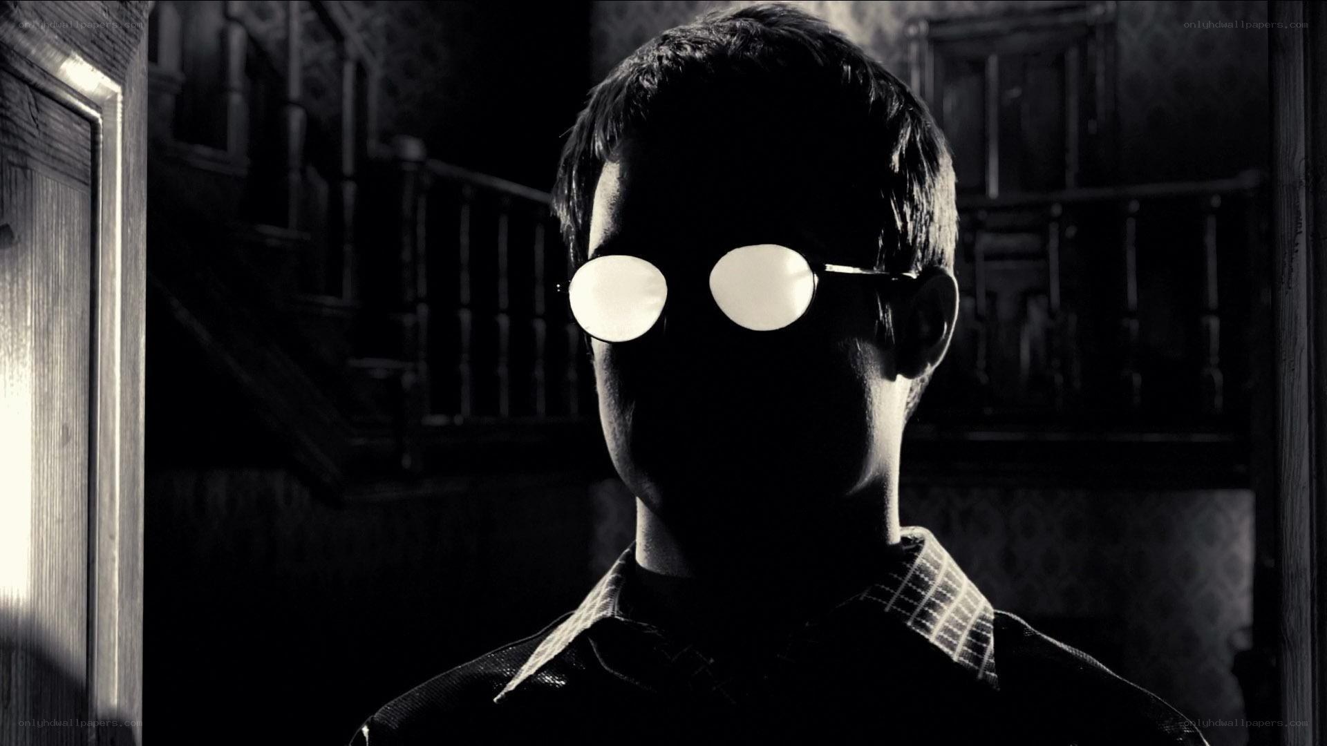 man in dark room with glasses