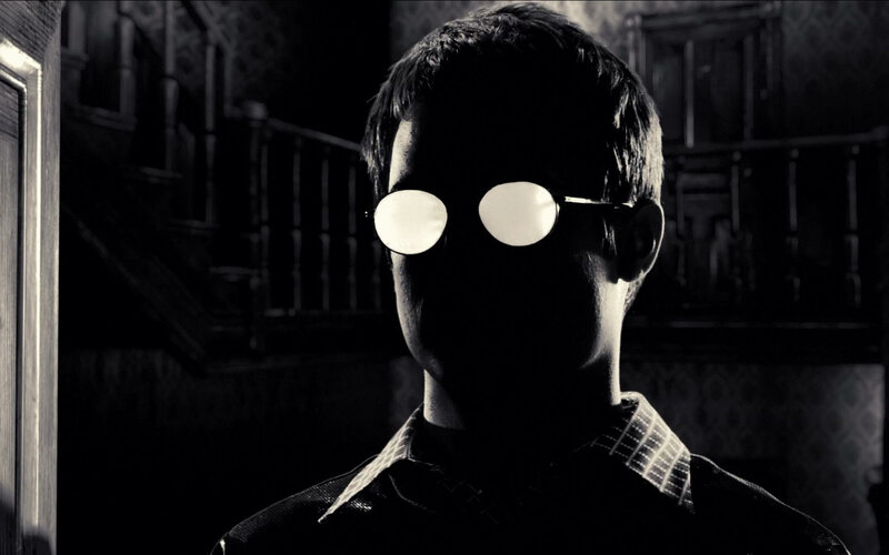 man in dark room with glasses