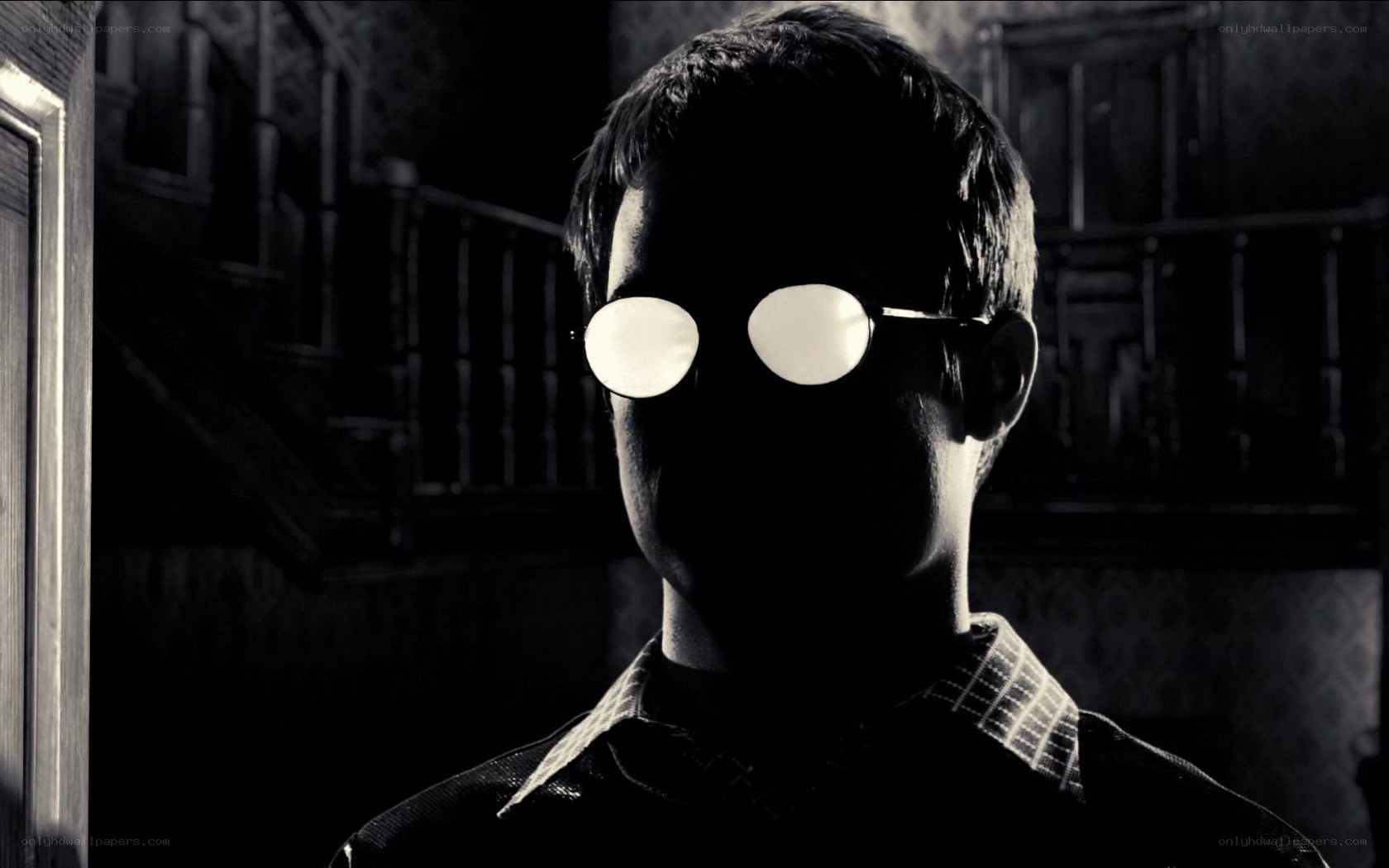 man in dark room with glasses