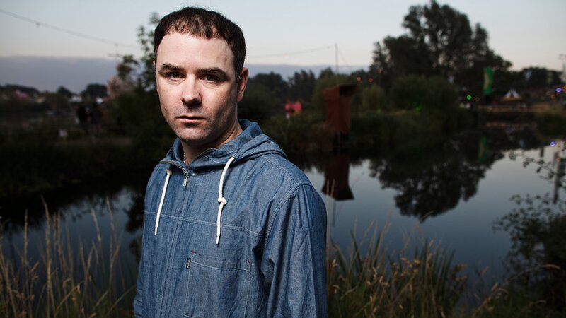 Man in denim hoodie by water
