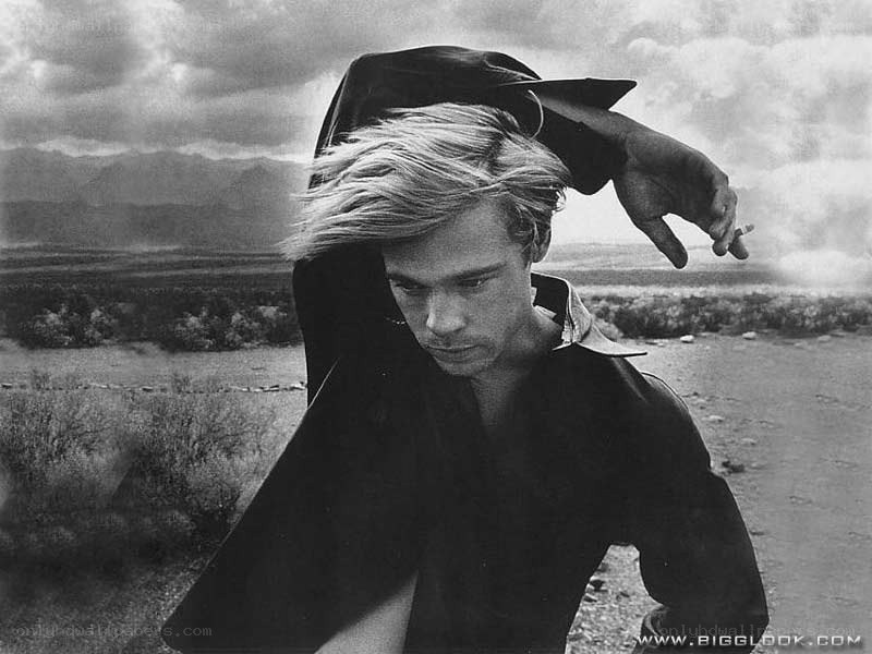 man in desert holding hat