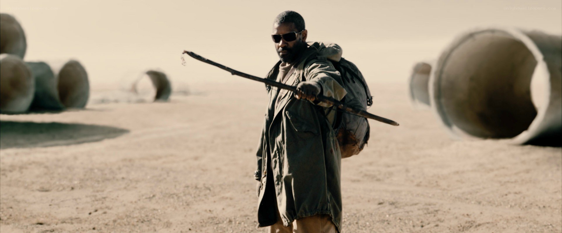 man in desert with stick