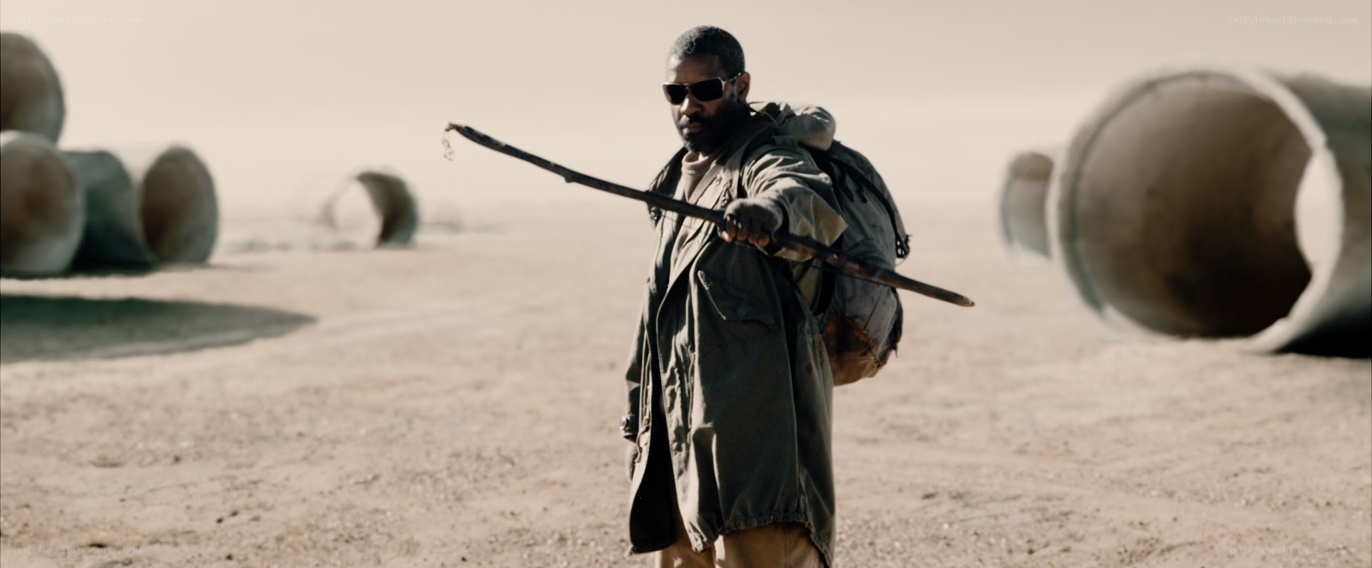 man in desert with stick