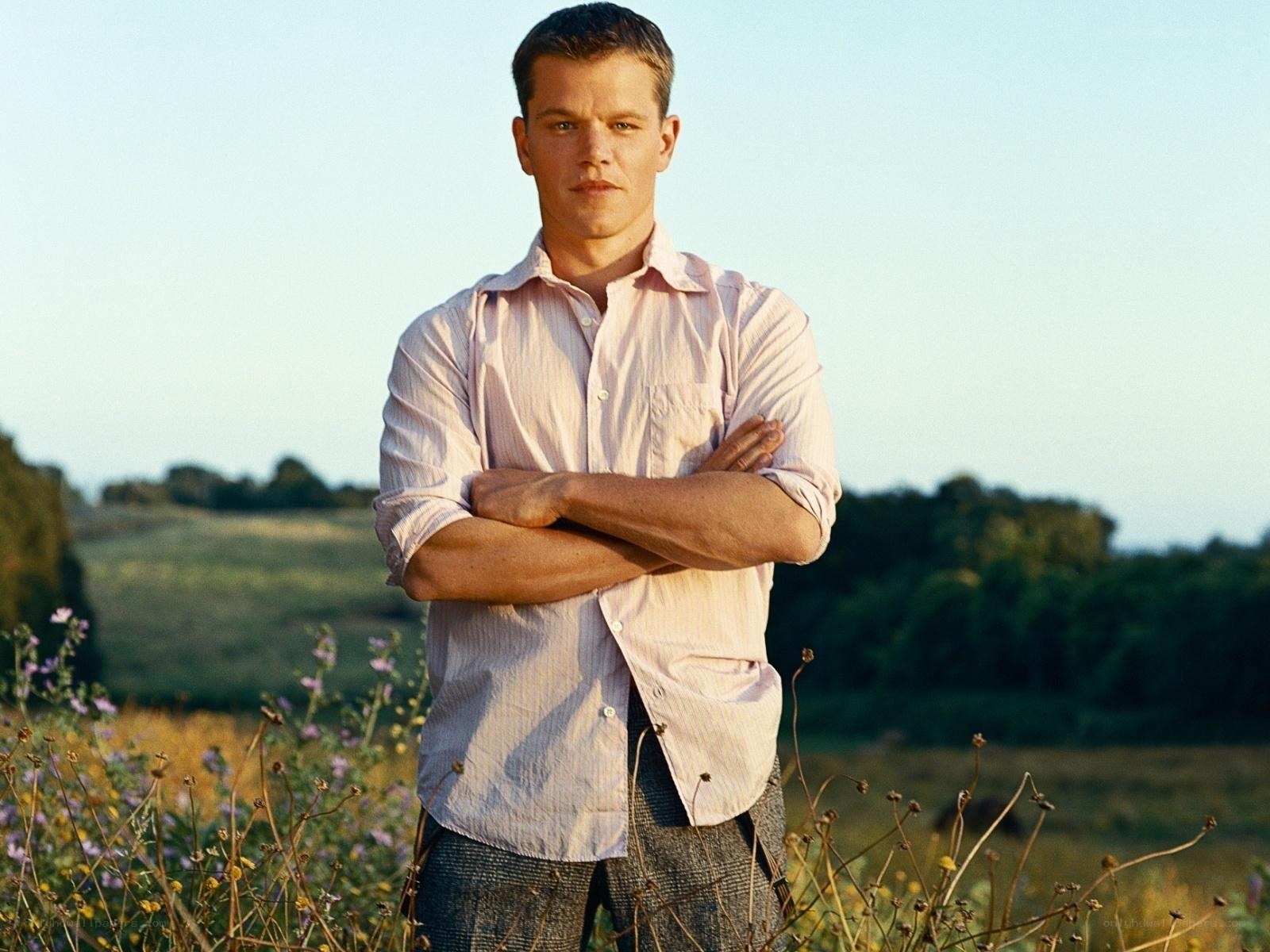 man in field with arms crossed