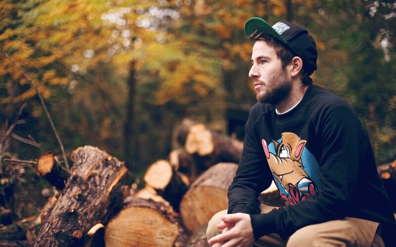 man in forest with logs