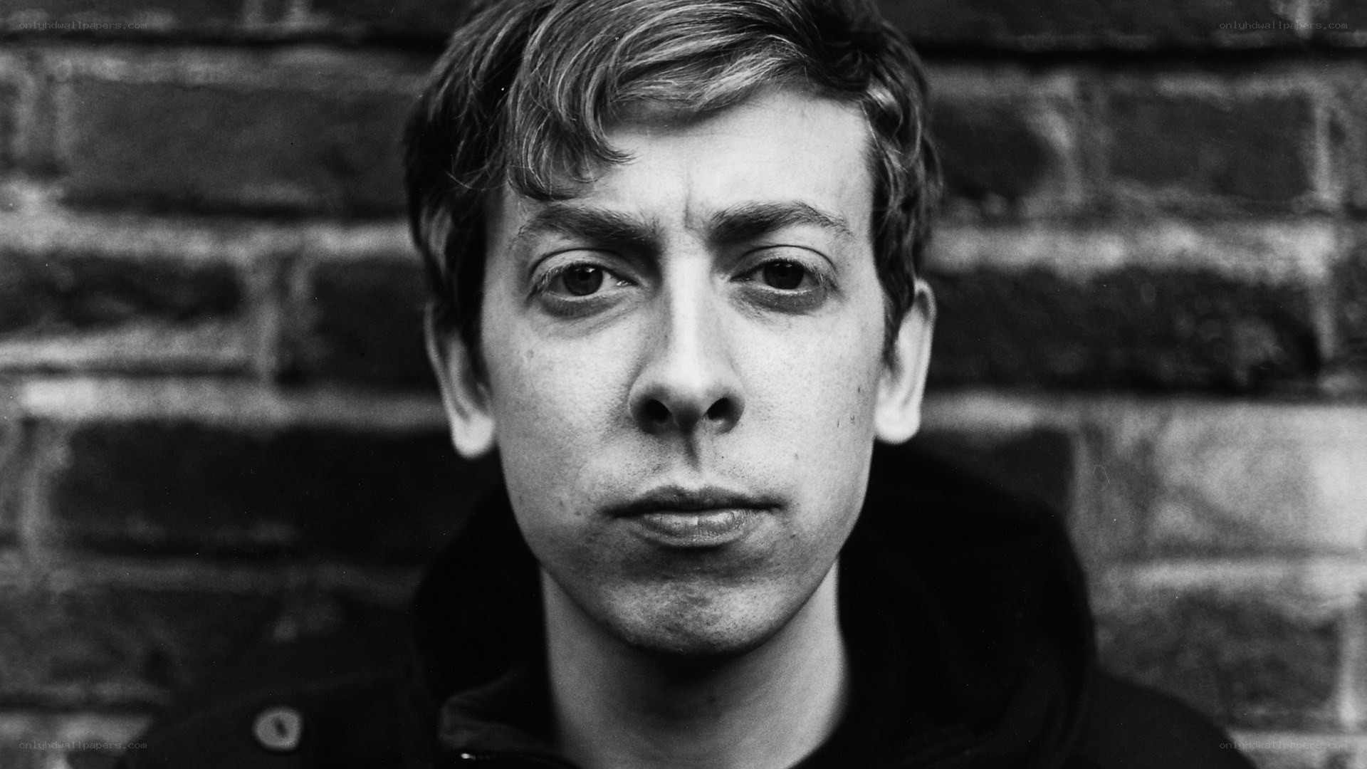 man in front of brick wall