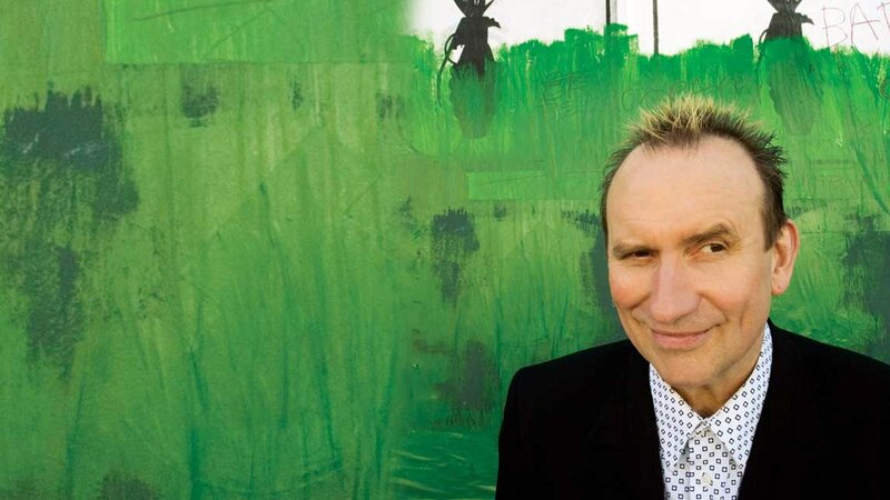 man in front of green wall