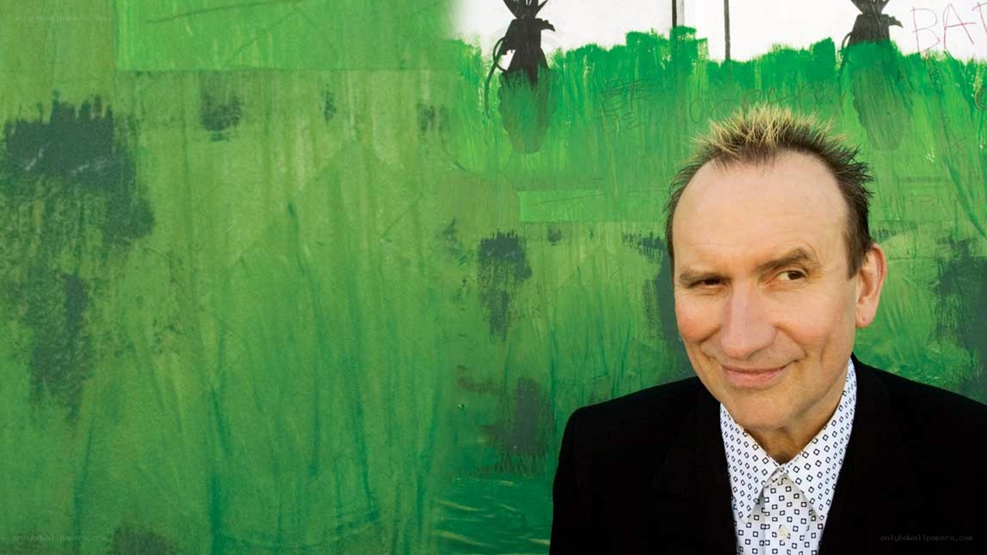 man in front of green wall