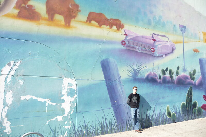Man in front of mural