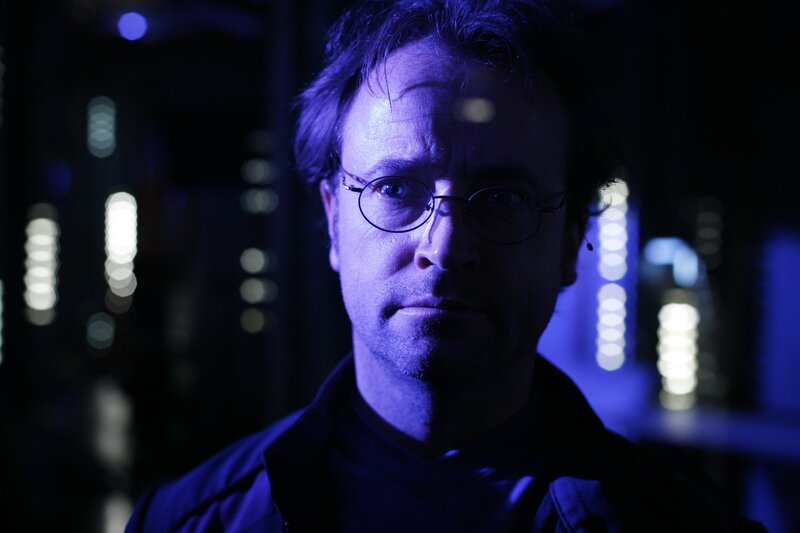 man in glasses under blue light