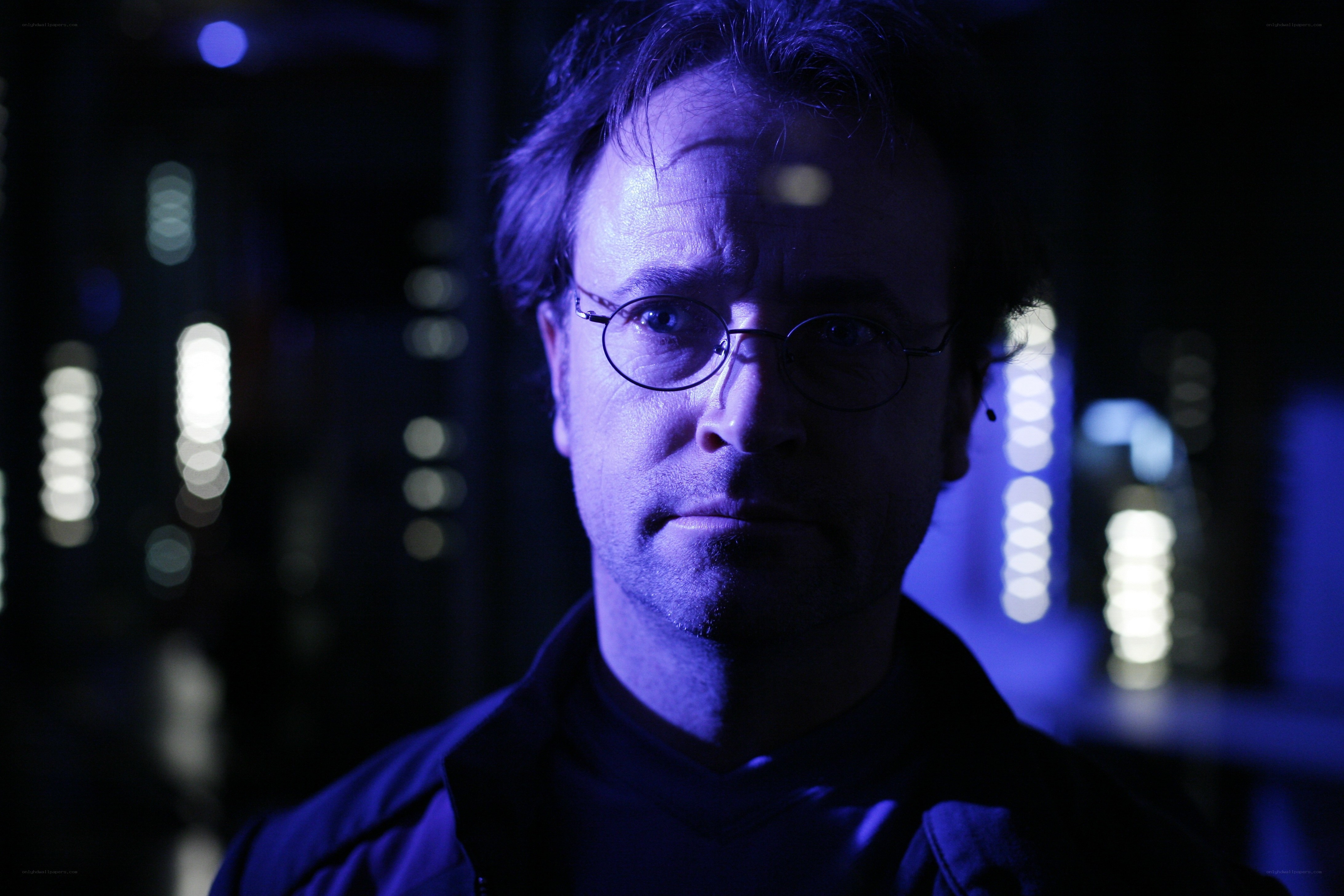 man in glasses under blue light