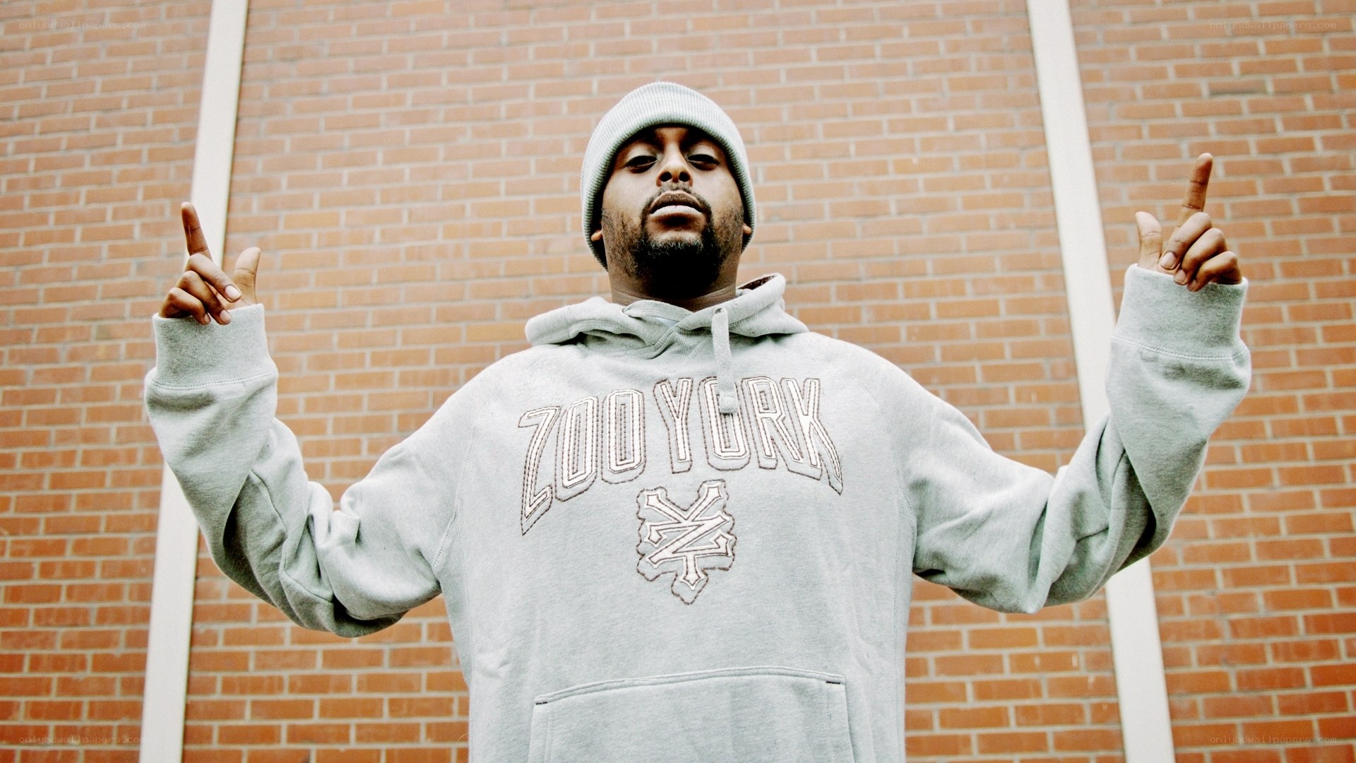 Man in gray hoodie pointing up