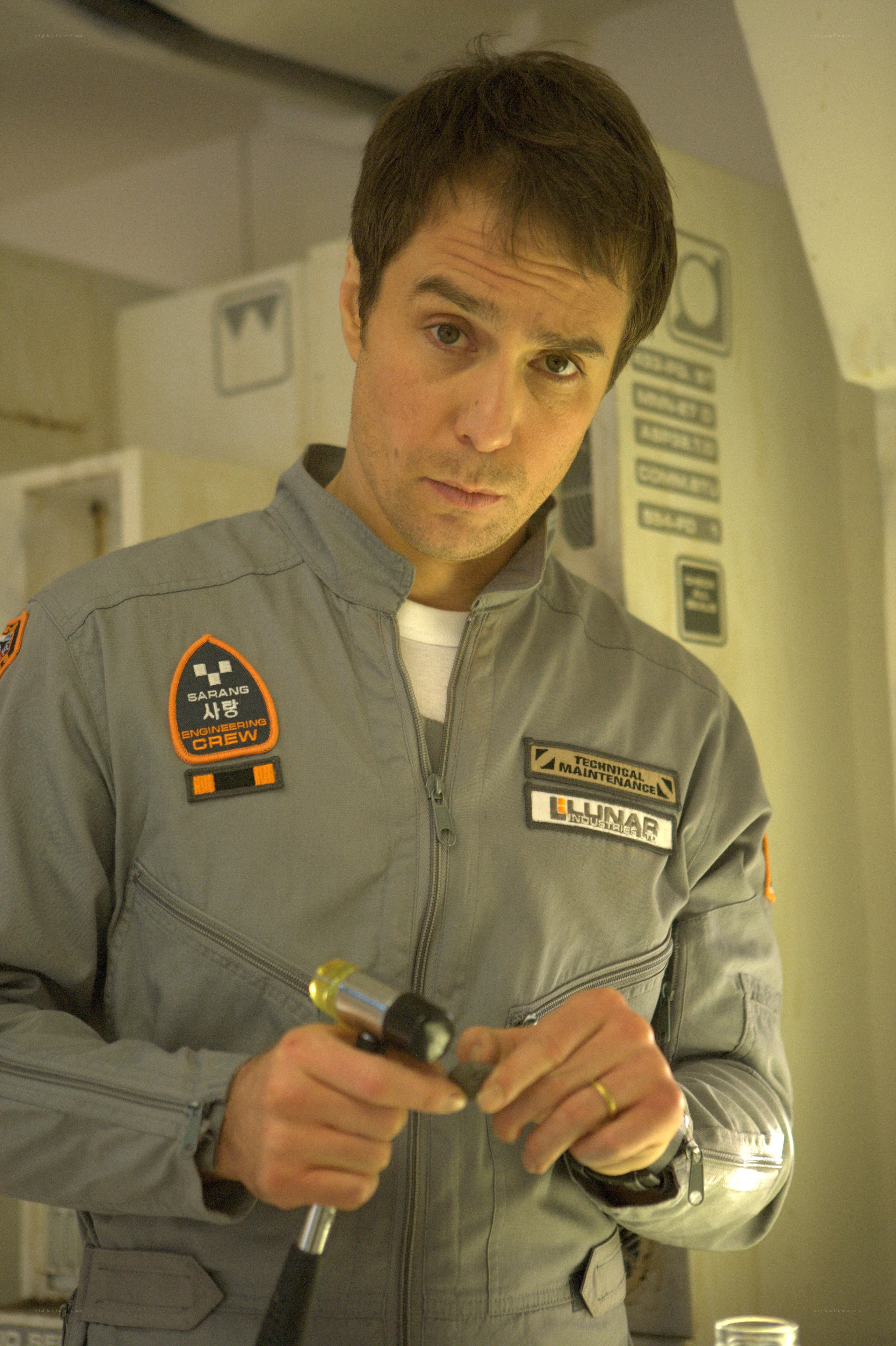 man in gray uniform holding tool