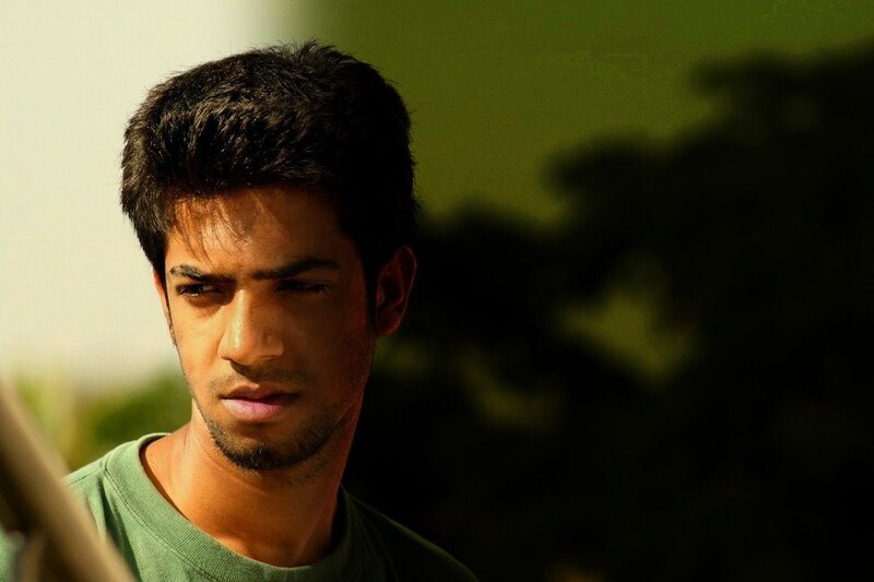 man in green shirt looking down