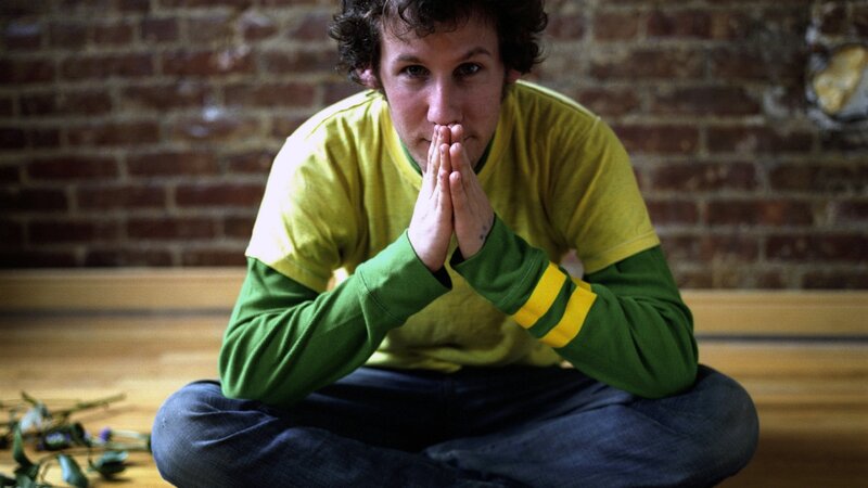 man in green shirt sitting cross-legged