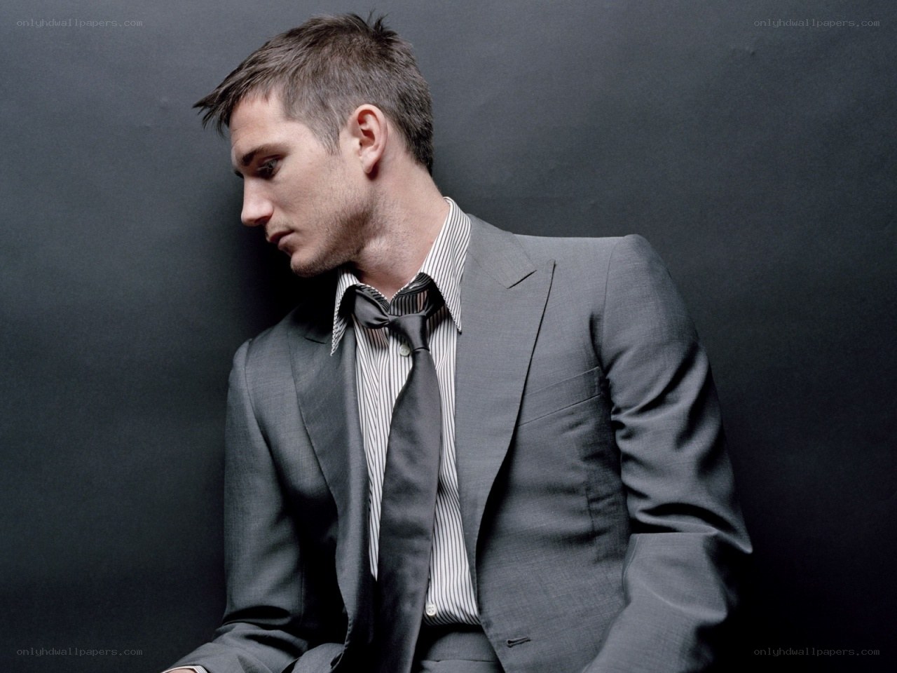 man in grey suit looking down