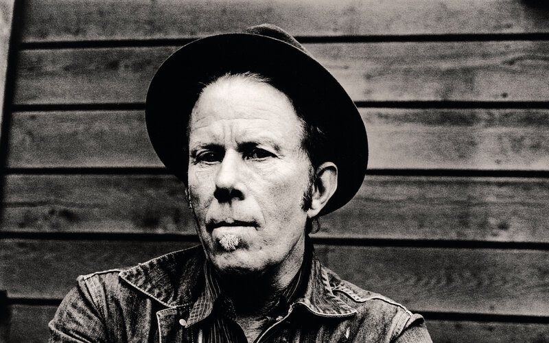 man in hat against wood wall