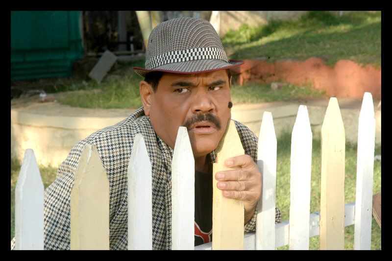 Man in Hat Behind Fence
