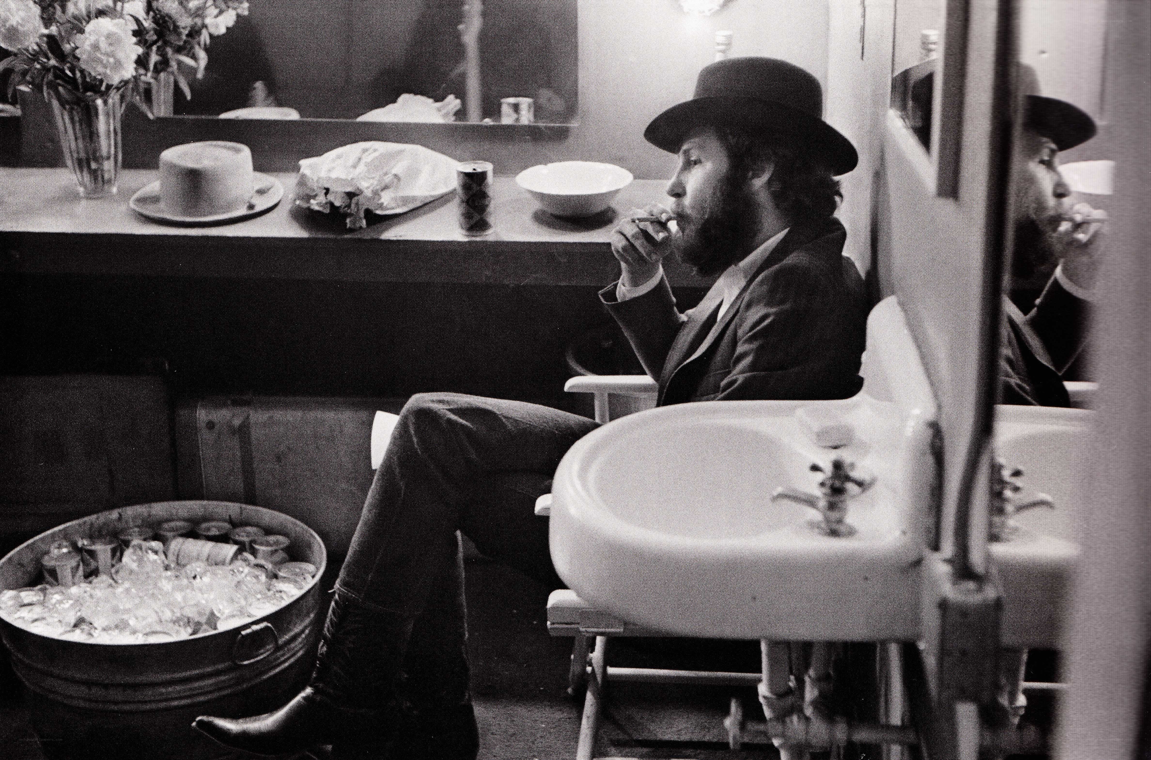 man in hat eating in dressing room