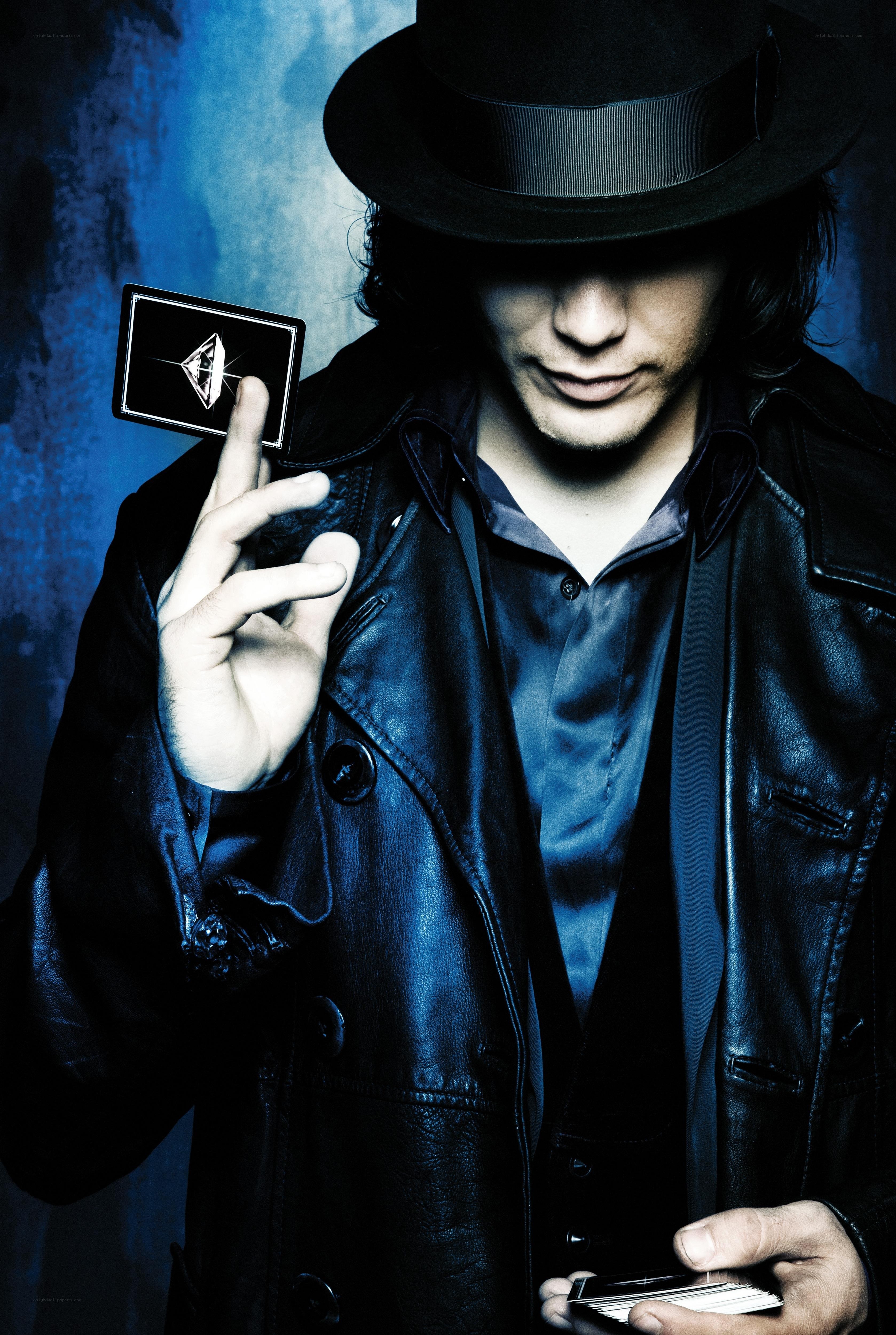 man in hat holding cards