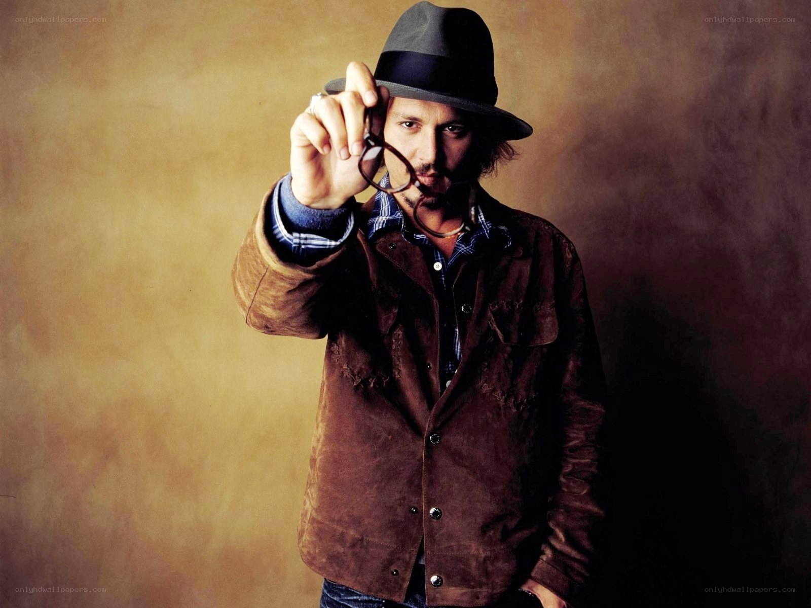 man in hat holding glasses