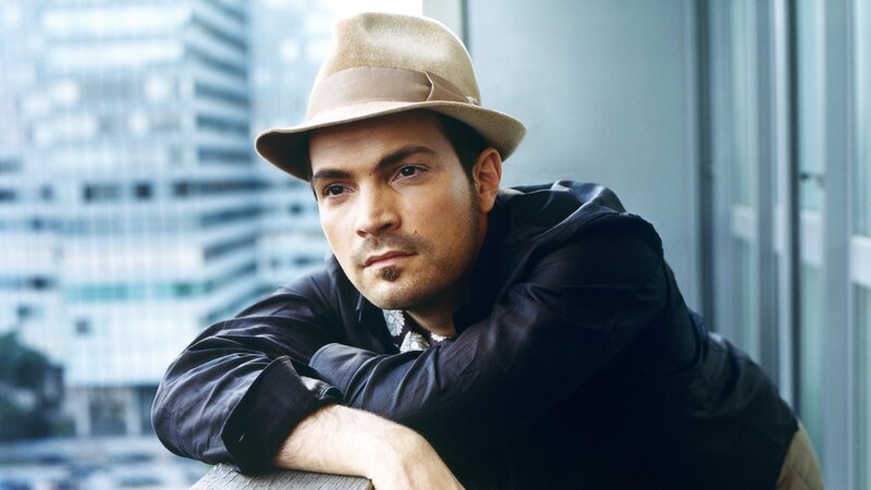 man in hat leaning on railing
