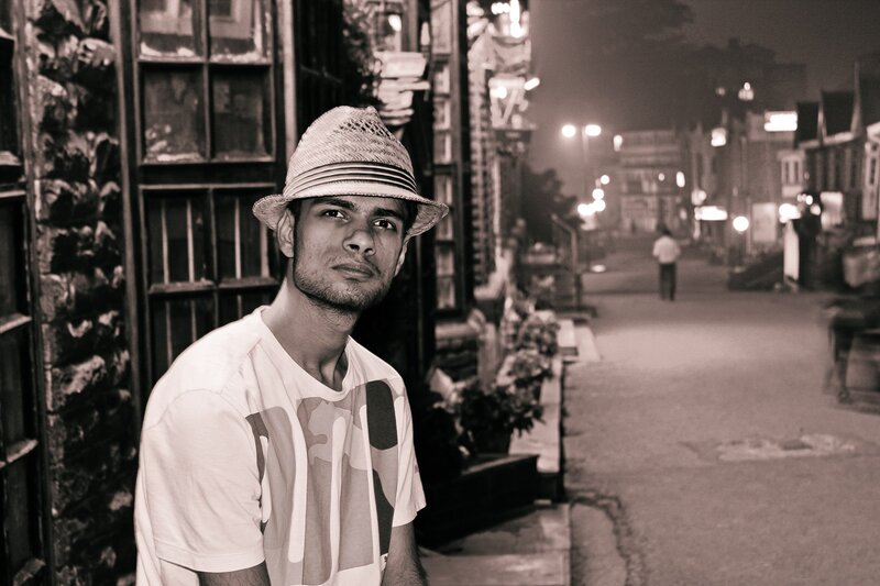 man in hat on street at night