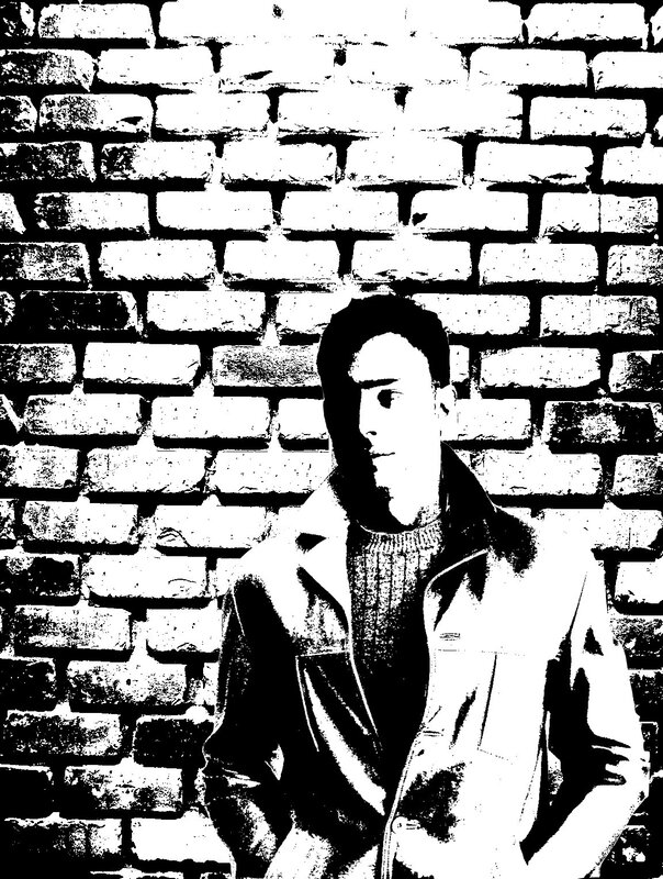 man in jacket against brick wall