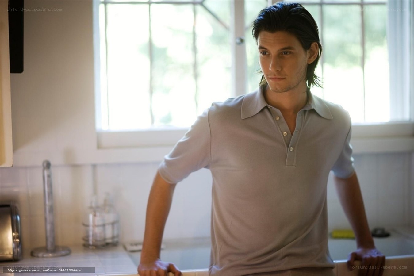 man in kitchen wearing polo shirt