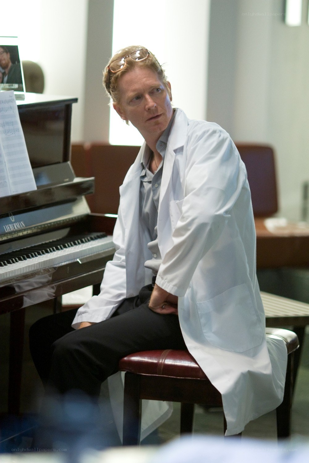 Man in lab coat at piano