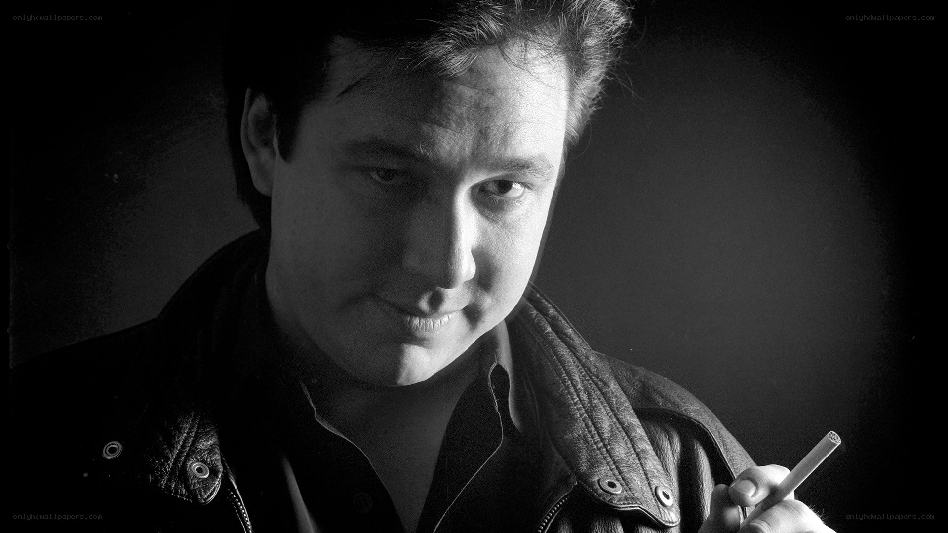 man in leather jacket holding cigarette