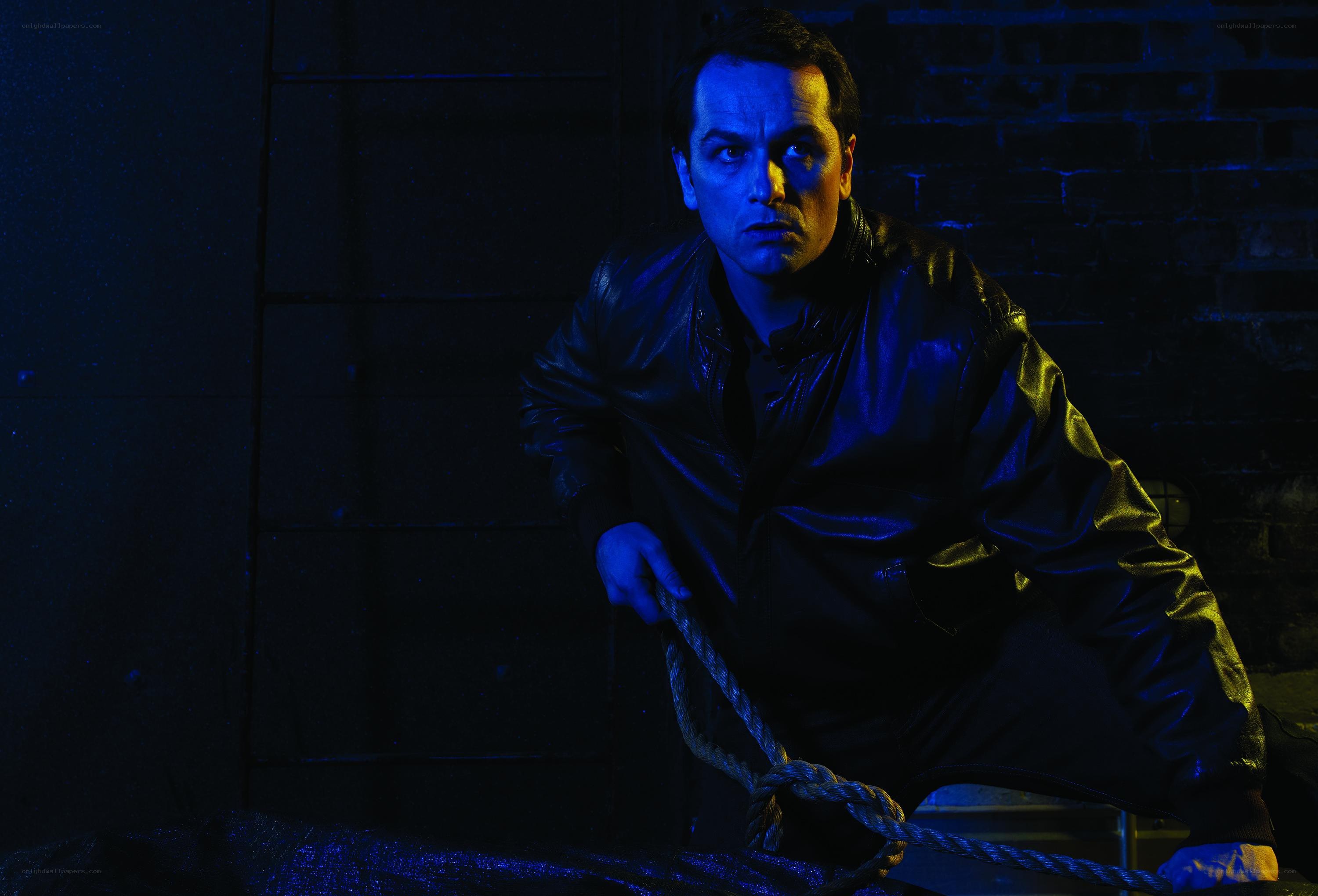 man in leather jacket holding rope