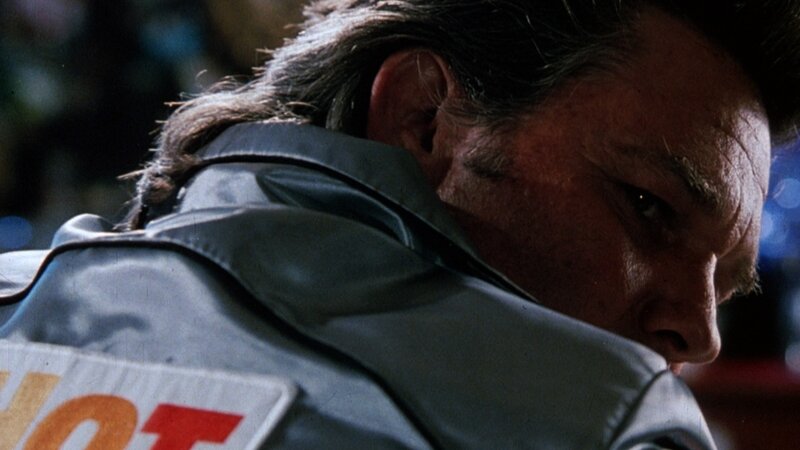 man in leather jacket looking down