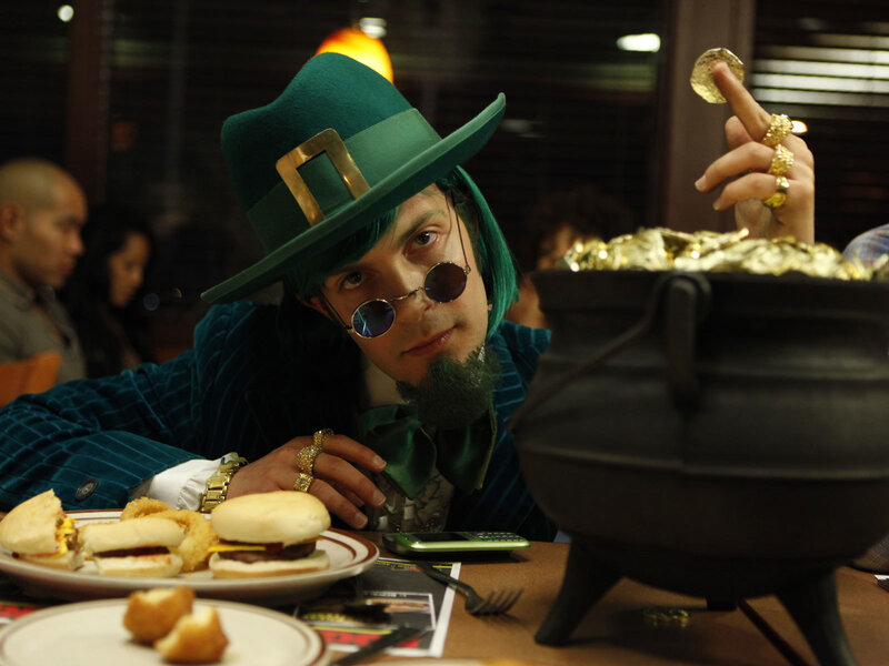 Man in leprechaun costume at table