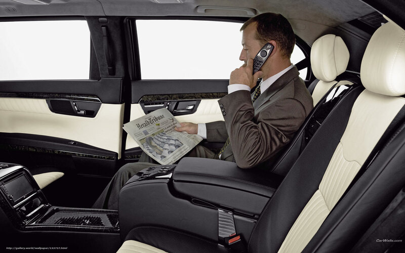 Man in luxury car reading newspaper