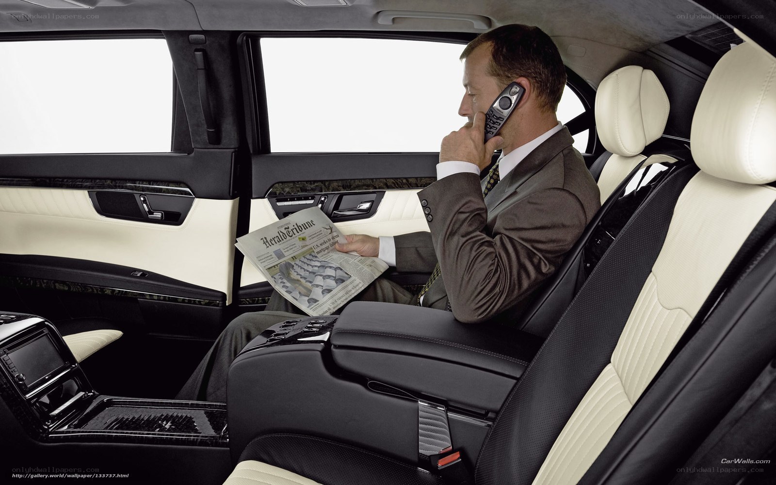Man in luxury car reading newspaper