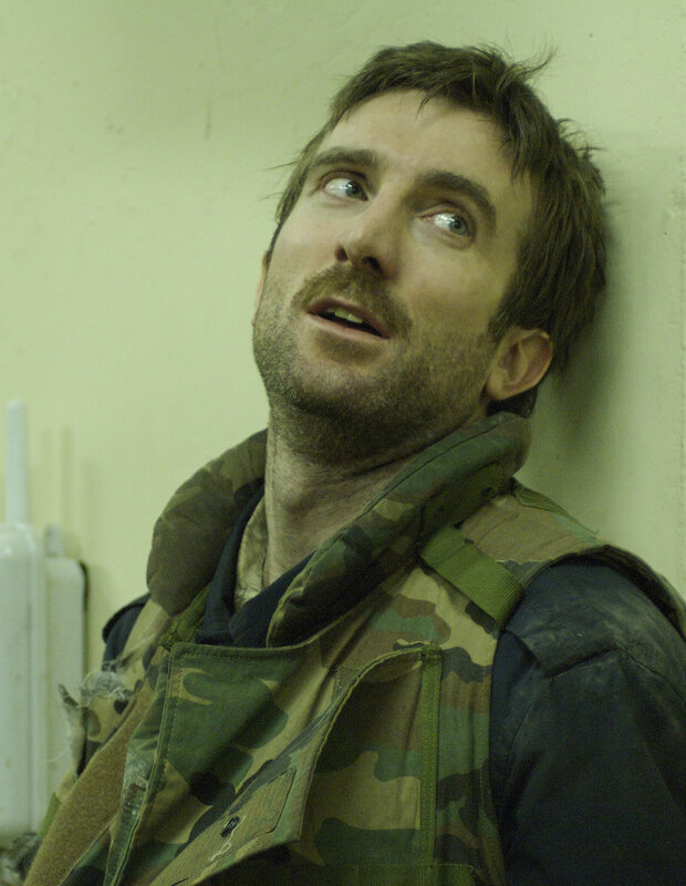 man in military vest looking up
