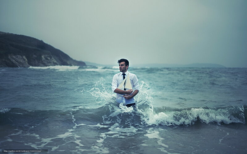 Man in Ocean Holding Sailboat