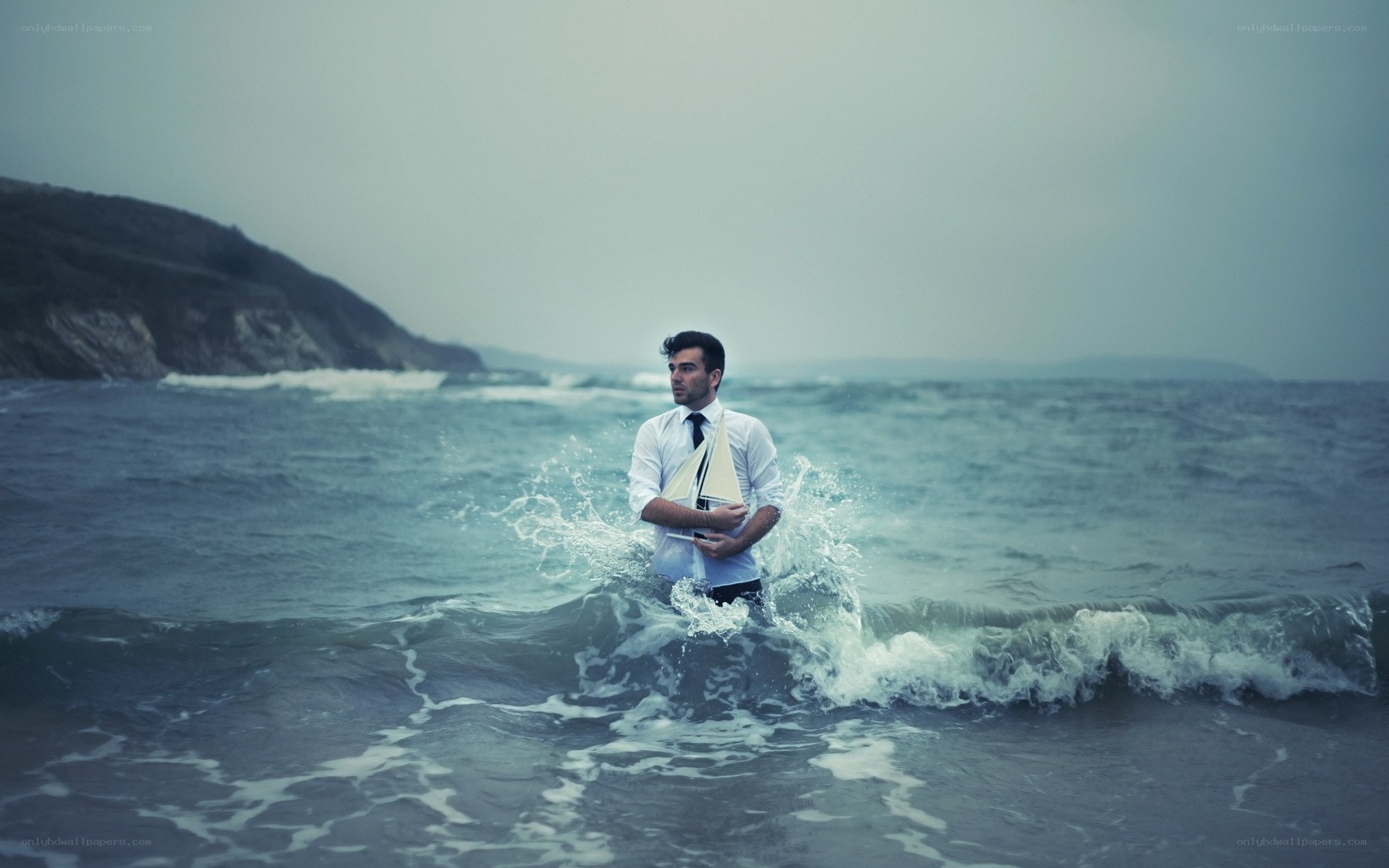 Man in ocean with sailboat