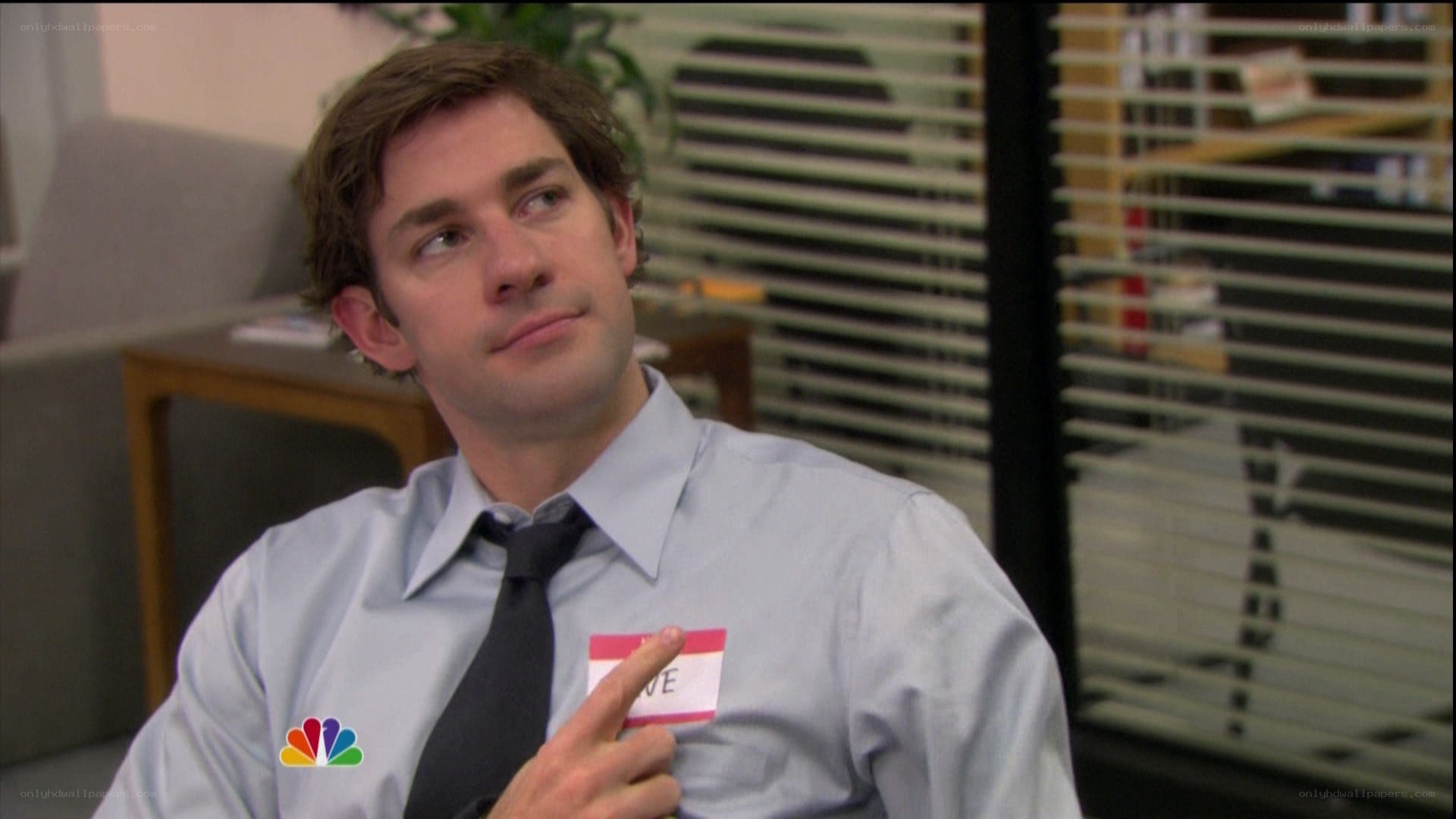man in office pointing at name tag