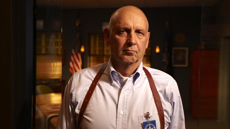 man in office with suspenders
