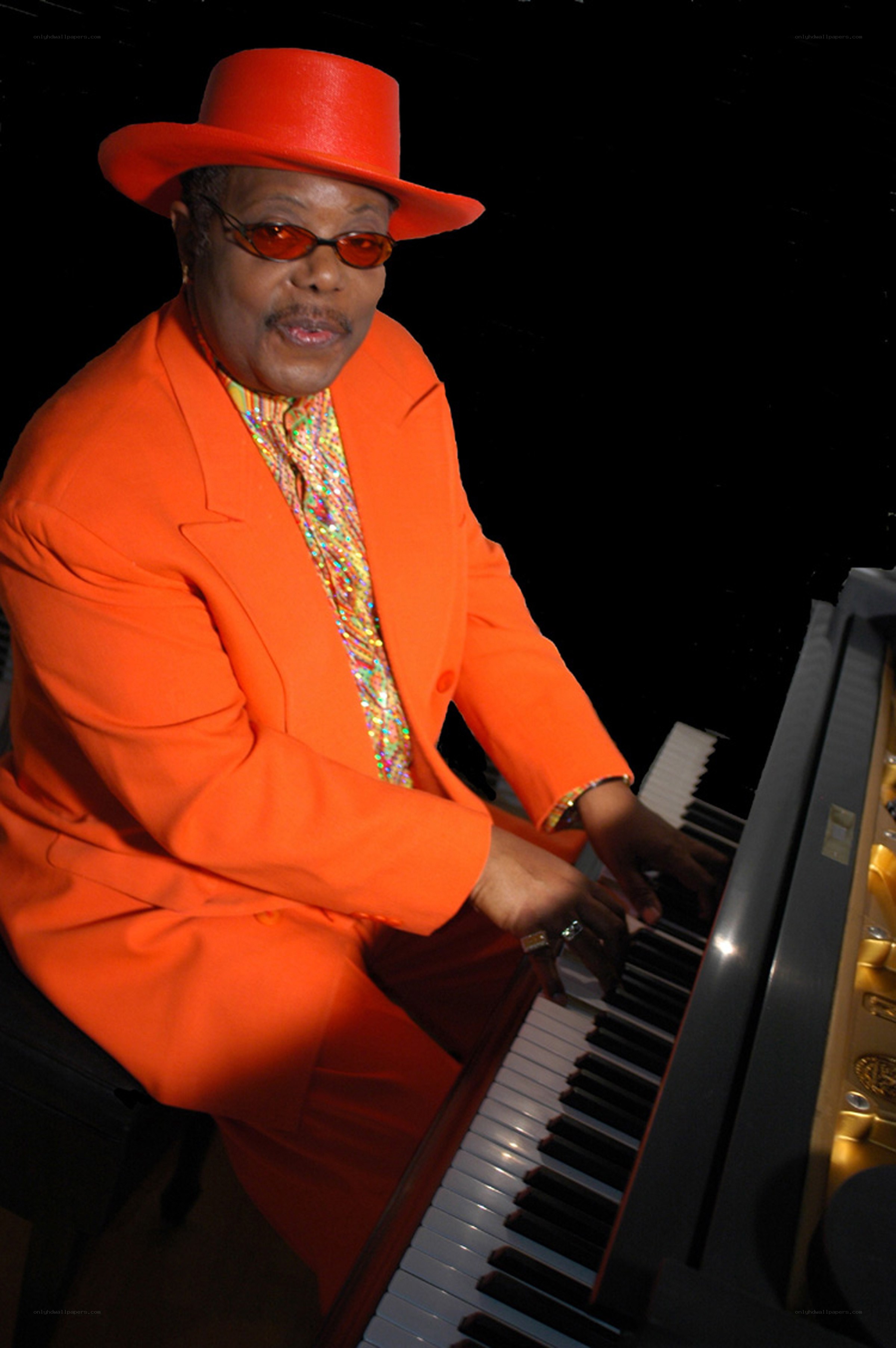 Man in orange playing piano