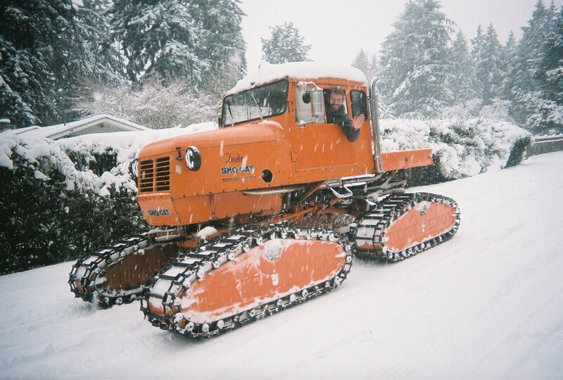 Man in orange snowcat vehicle