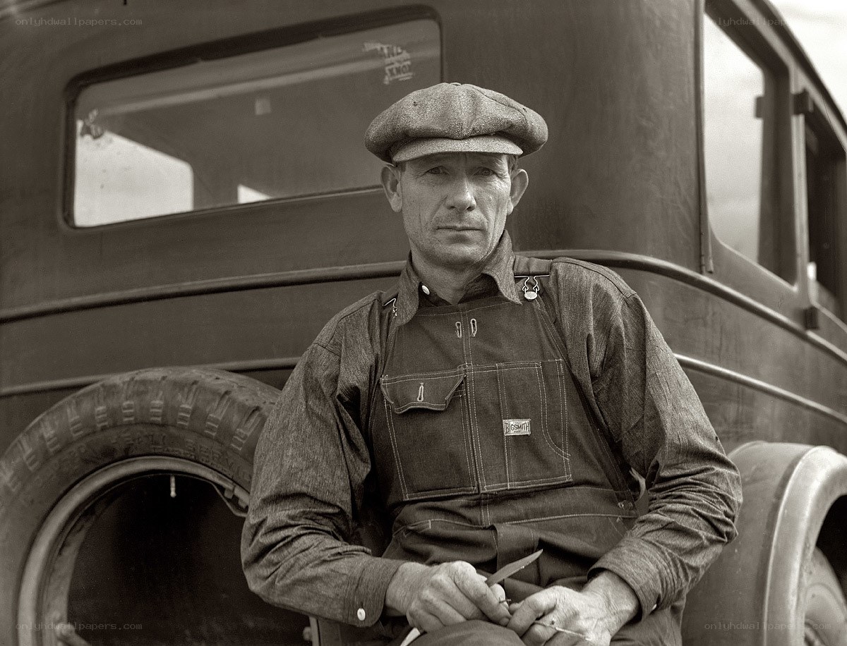 Man in overalls by a truck