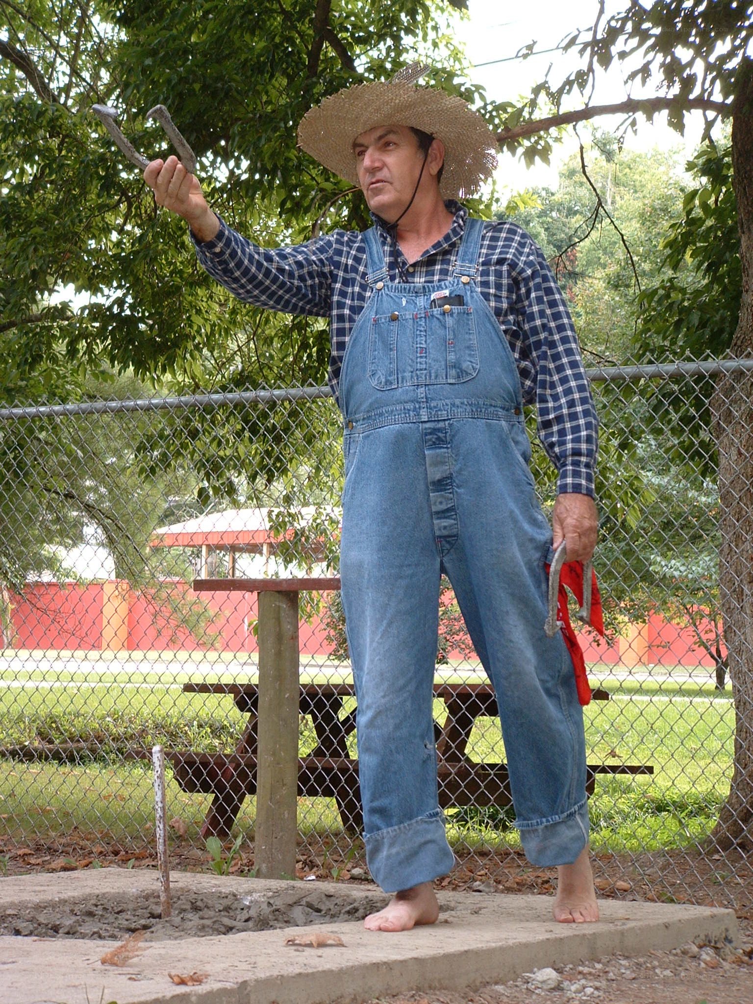 Man in overalls holding horseshoes