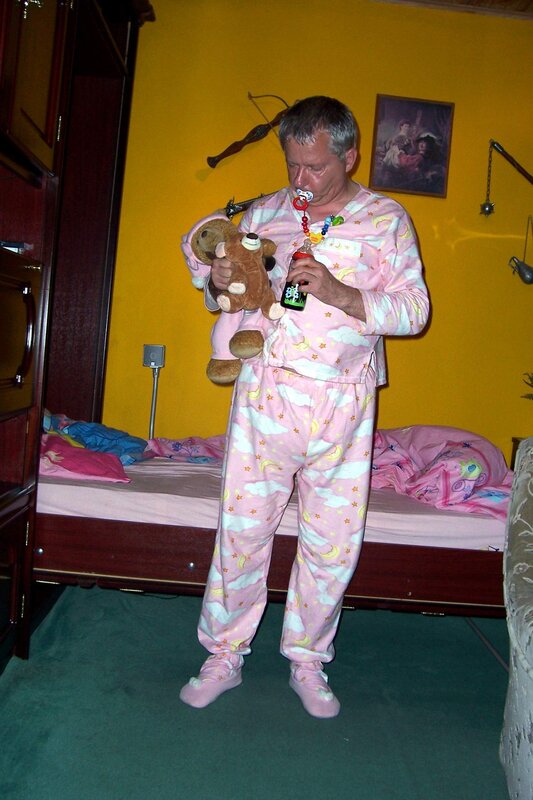 Man in pink pajamas holding teddy bear