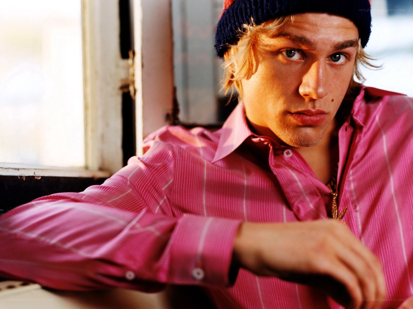 man in pink shirt and beanie