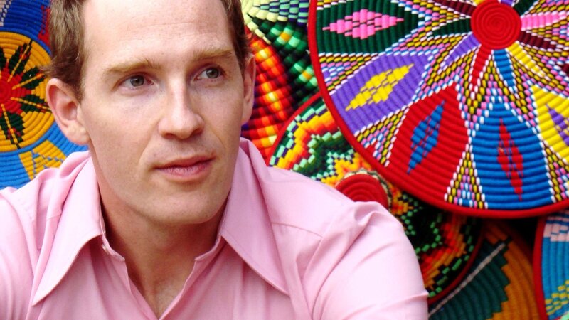 man in pink shirt with colorful baskets