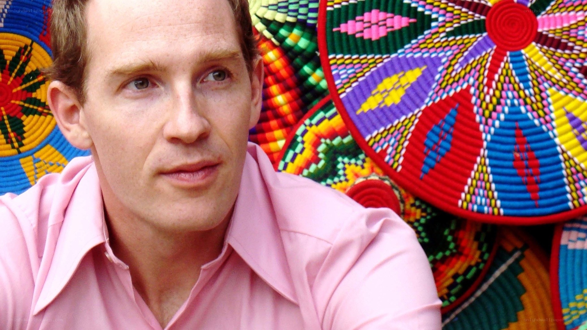 man in pink shirt with colorful baskets
