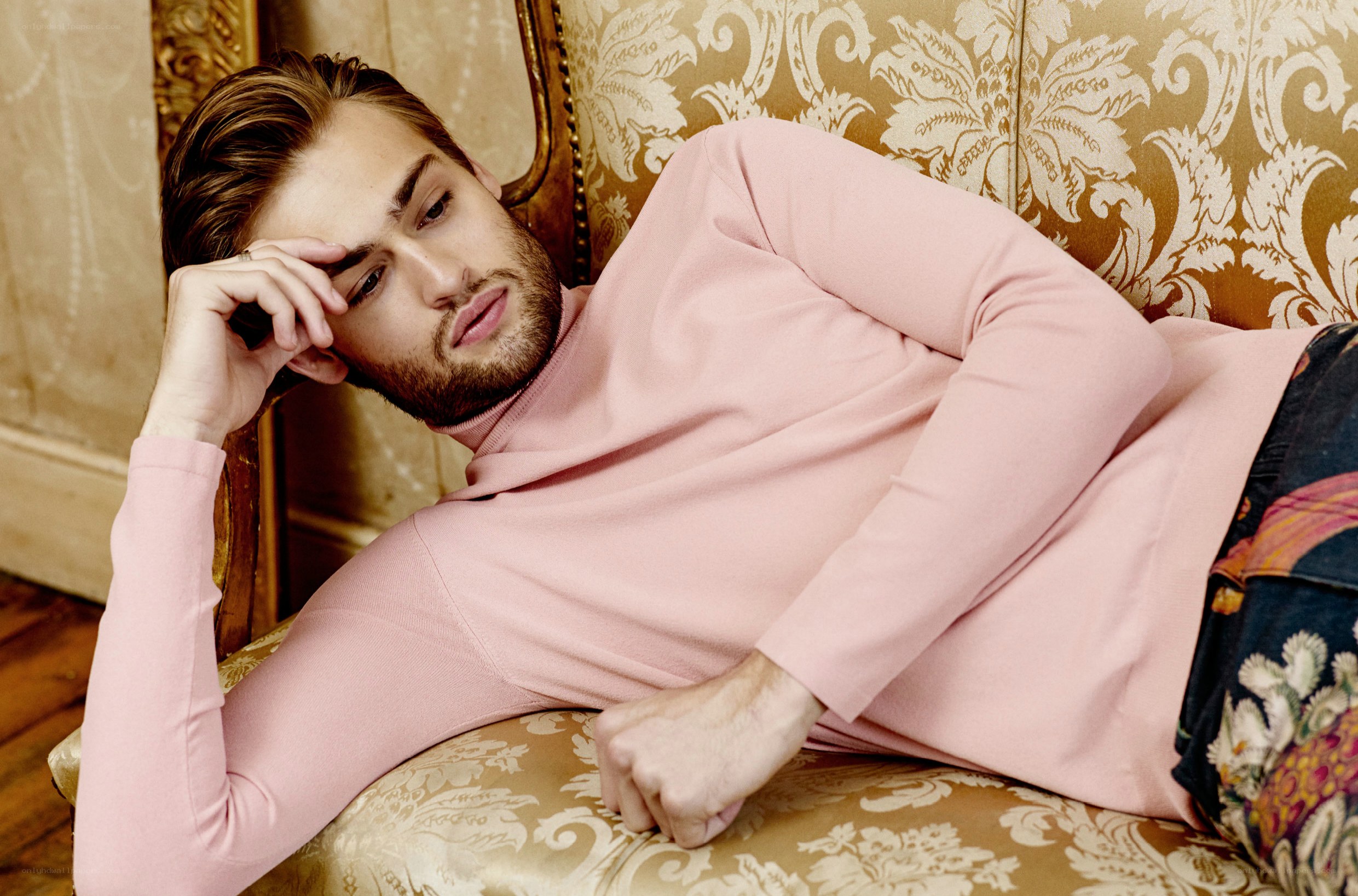 man in pink sweater on couch